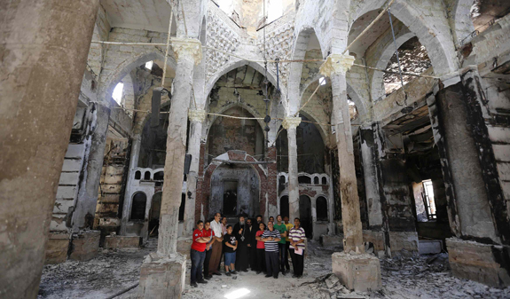 A Coptic Orthodox bishop prays with local residents at burnt and damaged evangelical church in Minya, Egypt, Aug. 26. (CNS photo/Louafi Larbi, Reuters)