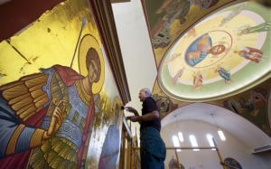 Elias Katsaros applies a thin coat of gold Saturday to a sticky adhesive on an icon in the dome he began many years before at St. John Chrysostom Antiochian Orthodox Church in Springettsbury Township. Saints George and Demetrius, the icons he is working on, were Roman warriors who died for their Christian beliefs.