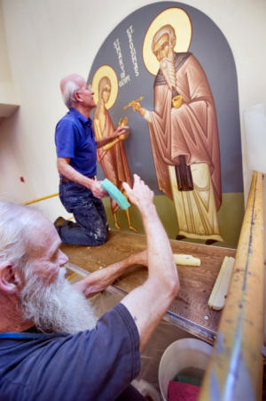 Gary Stump, bottom, of Springettsbury Township and a member of the church, keeps fresh sponges at the ready as the canvas is attached to the wall last week. Now retired, Stump helped with earlier iconography installations at the church and is now able to devote much more of time for this installation. Retired from Verizon, where climbing utility poles was part of the job, Stump said he wasn't afraid of heights. Elias Katsaros, top, began painting iconography at St. John Chrysostom Antiochian Orthodox Church in Springettsbury Township in 1996.