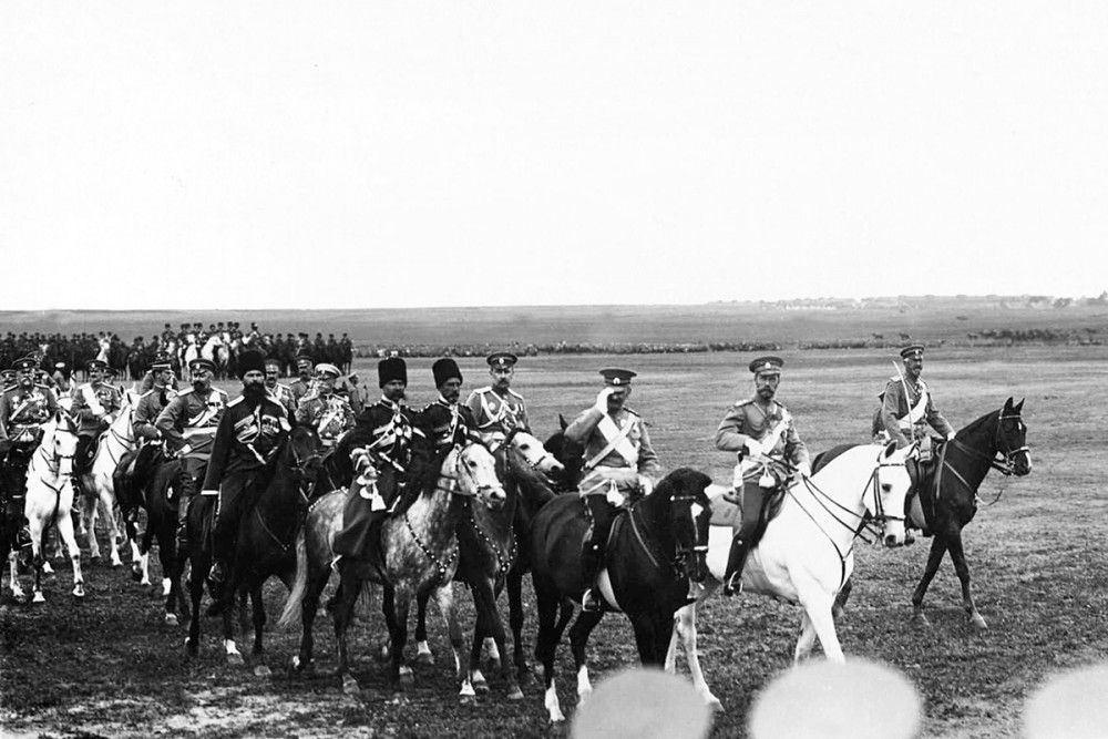 Император Николай II и датский король Фридрих VIII со свитой на военном поле объезжают фронт выстроенных на смотр войск. 7 июля 1909 г.