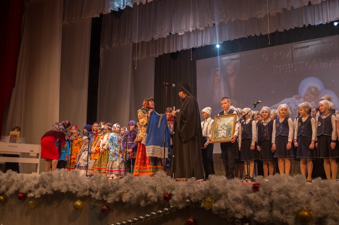 Марина Ростокина вручает традиционный русский костюм Епископу Югорскому и Няганьскому Фотию