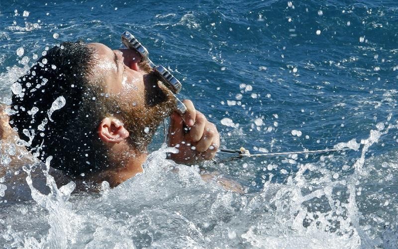 Ελλάδα. Ένας άνδρας είναι χαρούμενος, γιατί κατάφερε να πιάσει τον Σταυρό, που ρίχτηκε κατά τη διάρκεια του Αγιασμού των υδάτων