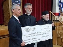 Bishop Paul presents $31K check to OCMC to buy motorbikes for Kenyan clergy