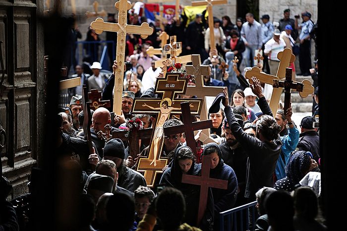 Pilgrims carrying wooden crosses enter the Holy Sepulchre Church during the Orthodox Good Friday procession. Photo: Thomas Coex/AFP