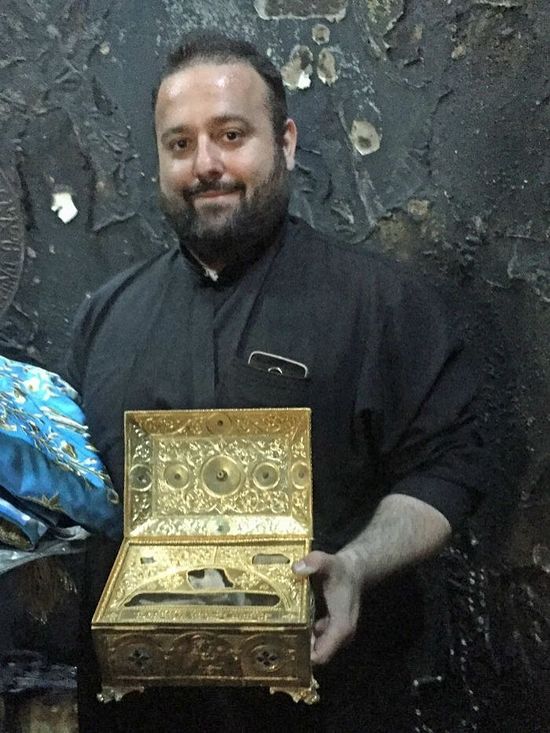 Father Michael Pfaromatis with the holy relics retrieved from the church's burnt altar. Photo: www.abc.net.au