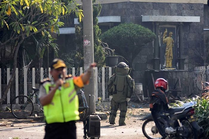 Полиция и сапёры у места взрыва бомбы у входа в католическую церковь Девы Марии в Сурабае, Индонезия