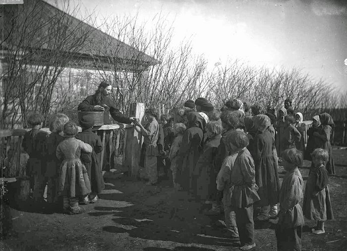 The distribution of bread among hungry children by Priest Moderatov. 1891-1892. The Lukoyan district, the Protasovo village. Photo by M.D. Dmitriev. 1892