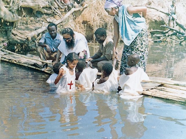 Отец Косьма крестит детей
