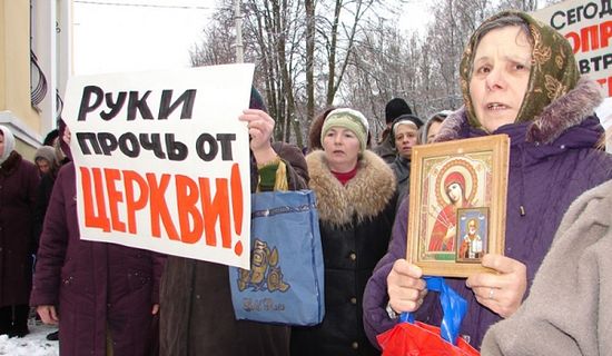 Women defend their church with icons and a sign that reads "Hands off the church." Photo: politnavigator.net