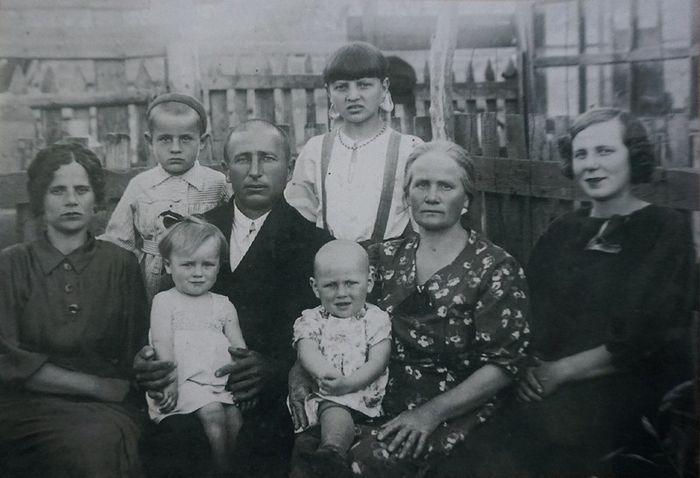 Семья Баклановых. Нина в нижнем ряду вторая слева на коленях у папы Якова перед отъездом его на фронт в 1943 г.