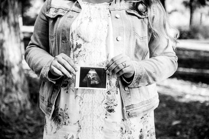 На фото женщина с изображением ее ребенка, сделанном в процессе ультразвукового исследования. Photo by Edward Cisneros on Unsplash