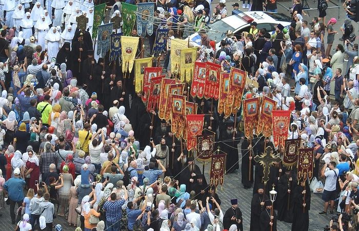 Members of the canonical church carrying religious banners and crosses.