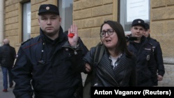 Activist Elena Grigorieva held by the police at a protest.