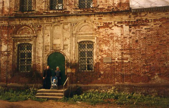 Fr. John and his matushka and child on the porch of the church. Photo: 40s.pereslavl.ru