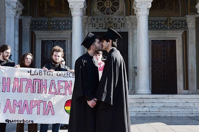 Gay rights activists dressed up as Orthodox priests kiss next to the Metropolitan church in Athens on December 22, 2015. (LOUISA GOULIAMAKI/AFP via Getty Images)