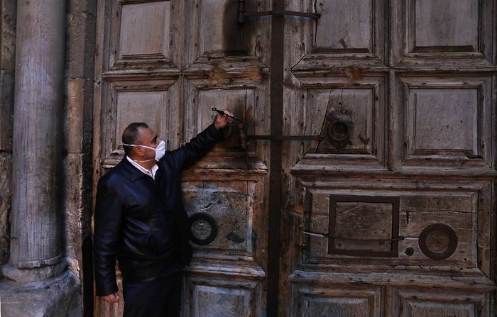  Adeeb Joude, the custodian in charge of the ancient key to the Church of the Holy Sepulchre, closes the entrance gate to the church due to the coronavirus (COVID-19) pandemic, in Jerusalem's Old City on March 25, 2020. (Ahmad GHARABLI / AFP)