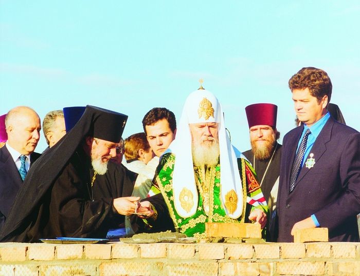 Святейший Патриарх Алексий II закладывает капсулу с посланием потомкам в основание храма Георгия Победоносца. Слева – владыка Сергий, справа – Вячеслав Сонин. 19 октября 1999 года