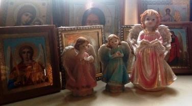 Фигурки «ангелов» в церковной лавке рядом с православными иконами