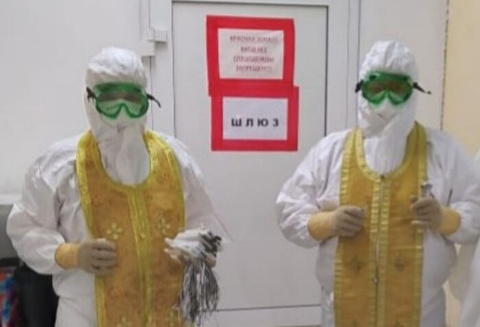 Священники в костюме СИЗ перед посещением красной зоны больницы