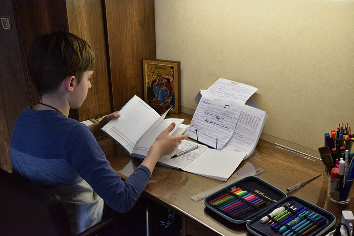 Старший Илья в своей комнате за уроками