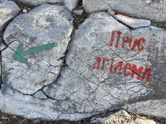 A sign painted on the rocks: ‘Pros agiasma’ (‘To the sacred spring’)