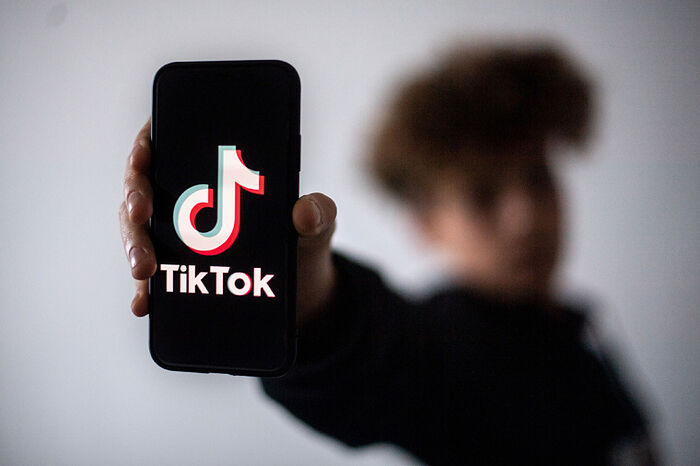 Подросток представляет смартфон с логотипом китайской соцсети TikTok 21 января 2021 г. в Нанте, Франция. Фото: LOIC VENANCE / Getty Images