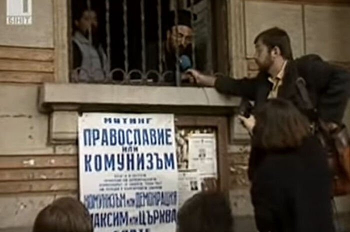 Христофор Сыбев дает интервью через окно захваченного раскольниками здания.