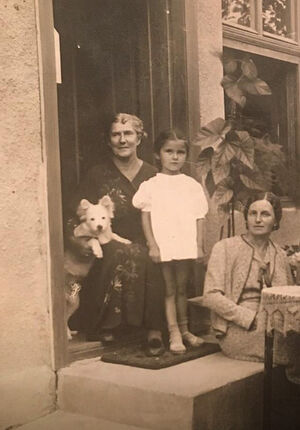 Бабушка сидит за столом, рядом стоит моя мама Мира в Крагуеваце (Сербия), 1940 год