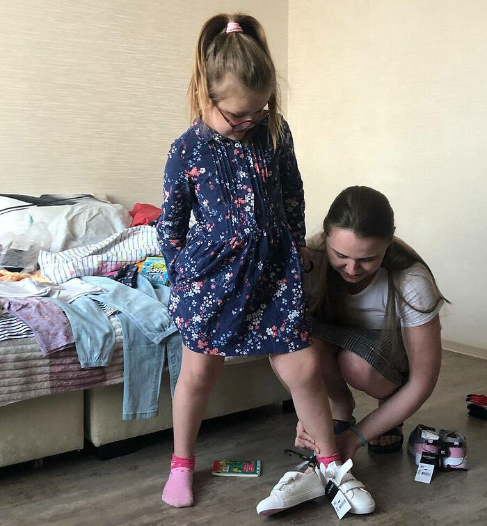 Наталья помогает своей дочери примерить подарок – новую весеннюю обувь