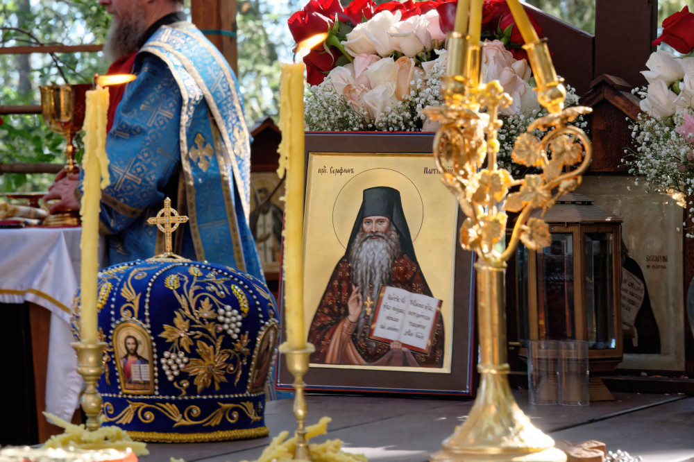 An icon of Fr. Seraphim and a bishop's miter on his grave, which is used as an altar table for serving Liturgy on special feasts