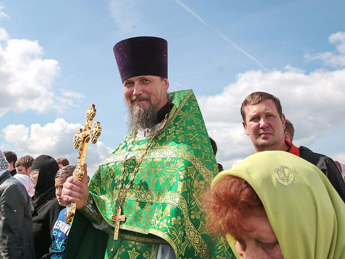 Fr. Andrew Samsonov in a procession with the cross at the settlement