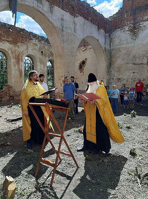 Prayer service within the walls of the ruined church. Fr. Dionisy and Fr. Valery