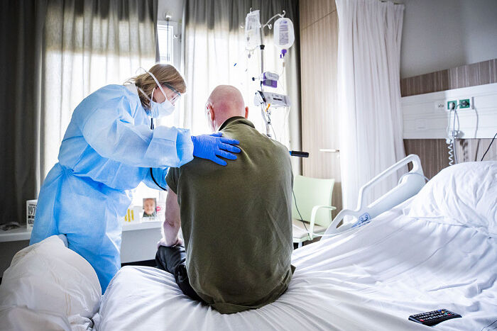 Лечащий врач слушает пациента, который выздоравливает после перенесенной коронавирусной инфекции в отделении интенсивной терапии больницы HMC Westeinde в Гааге, 4 апреля 2020 г. Фото: РЕМКО ДЕ ВААЛ/ANP /AFP / Getty Images