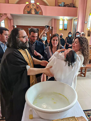 Священник Хорхе Суэц совершает таинство Крещения
